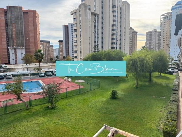View from a 4-bedroom apartment in Benidorm, showing a pool and greenery between the apartment buildings.