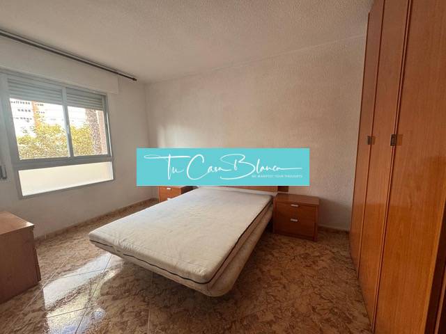 A bedroom in a 4-room apartment with a double bed and a floor with a wood decor.