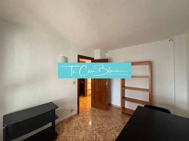 A room with light walls in a 4-room apartment with a wood-patterned floor.