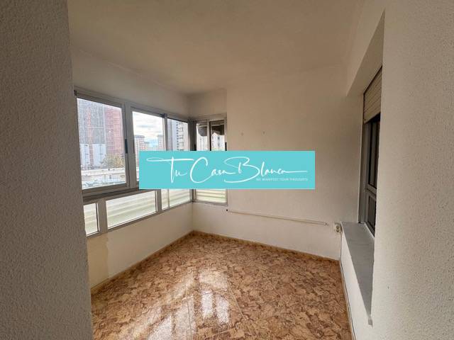 A room in a 4-room apartment with a wood-patterned floor and large windows.