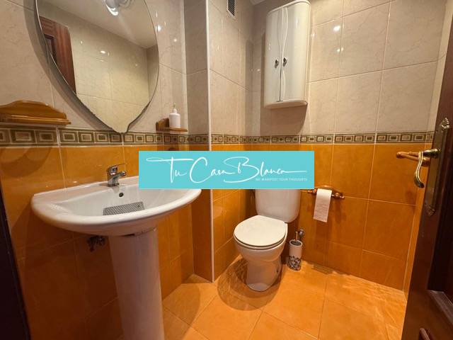 Bathroom in a 4-room apartment with a toilet and a floor with a wooden decor.