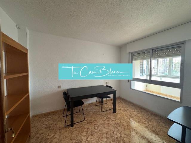 Interior of a 4-room apartment with a wooden decor floor and a table by the window.