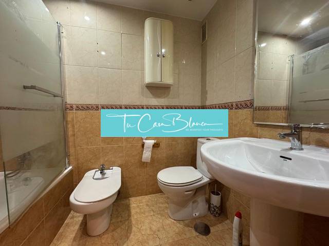 A bathroom in a 4-room apartment with a bathtub, bidet, and tiled floor.