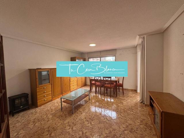 Living room with light furniture and a table, 4-room apartment, floor with wood decor.