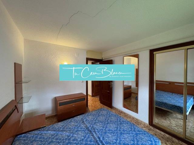 Bedroom in a 4-room apartment with wood-patterned flooring, built-in wardrobes, and a double bed.