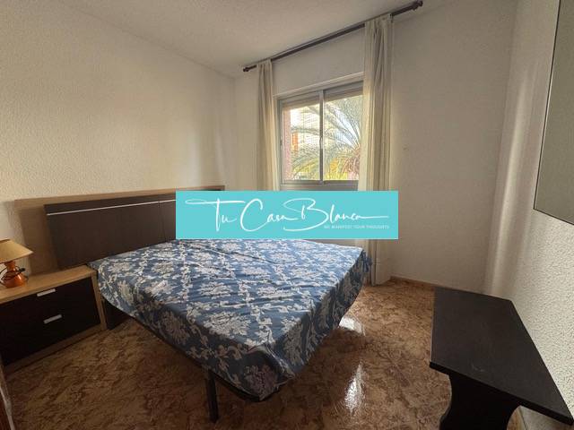 Bedroom in a 4-room apartment with a window and a wooden decor floor.