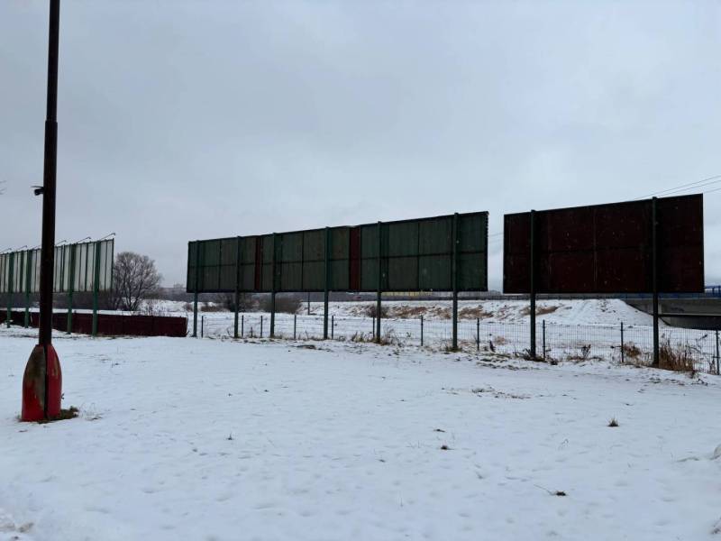 Snow-covered commercial spaces in Poprad with a row of empty advertising billboards on a snowy area.