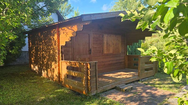 A wooden cottage surrounded by greenery in Úľany nad Žitavou, exudes a cozy and natural atmosphere.