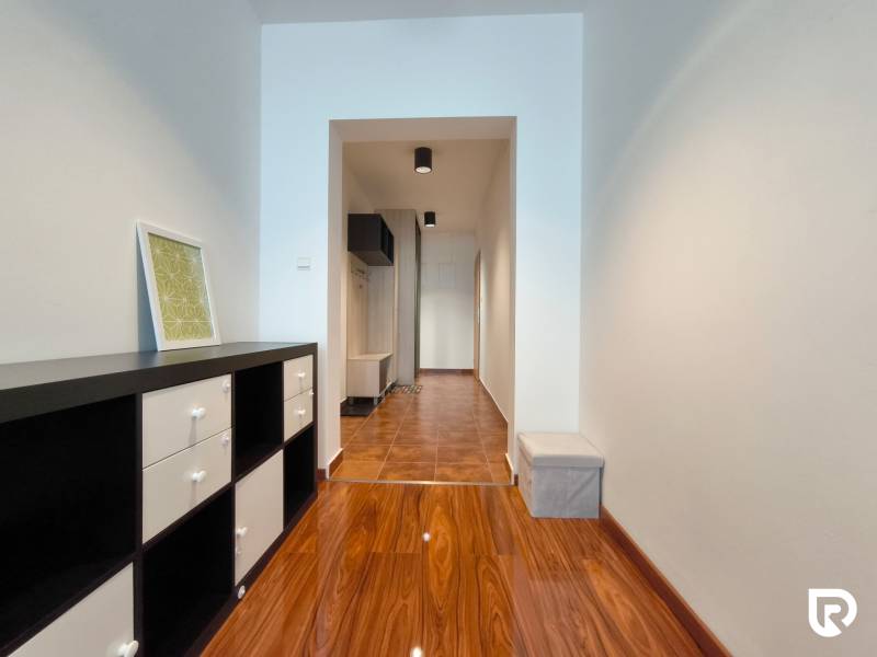 Entrance hall of a 2-room apartment with a wooden decor floor and furniture.