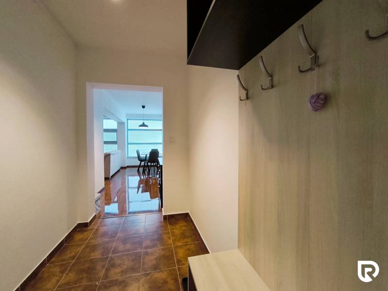 Hallway in a 2-room apartment, entrance to the living room with a dining table, floor with patterns.