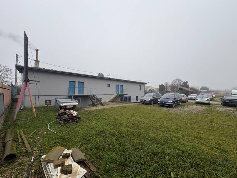 Parking lot with cars and an industrial building on Bratislavská Street in Veľký Biel. Land - residential.