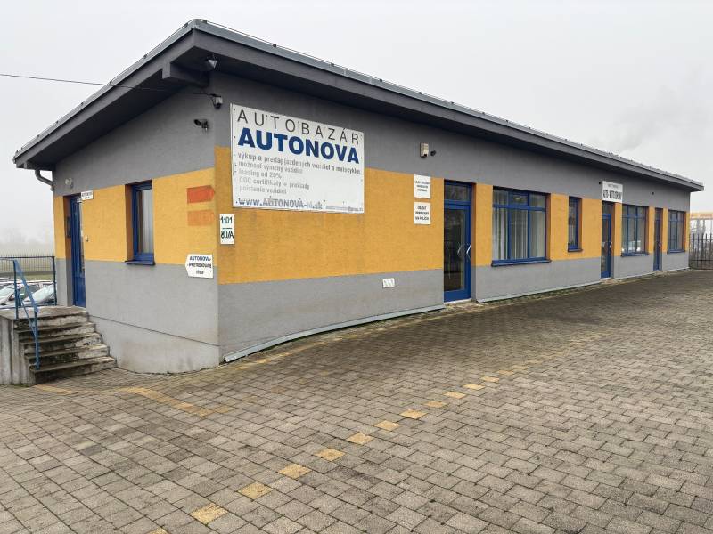 The car dealership on Bratislavská Street in Veľký Biel is surrounded by a paved area.