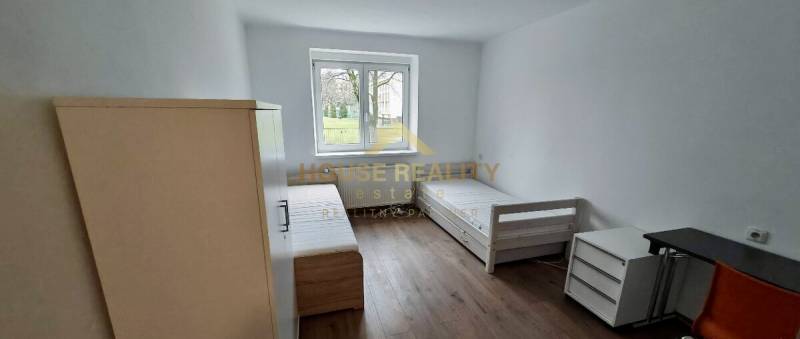 A bright interior in a 2-room apartment with two beds and a floor with a wooden decor.