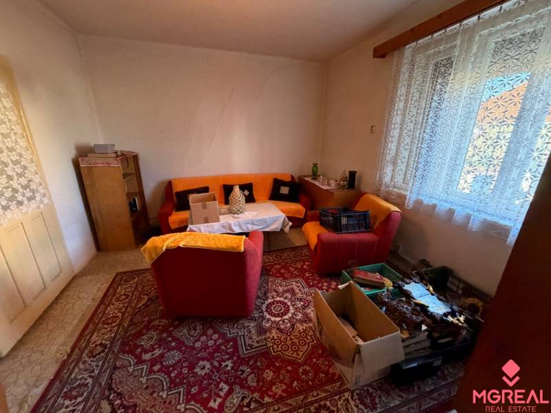 Living room in a family house with carpets and comfortable seating.
