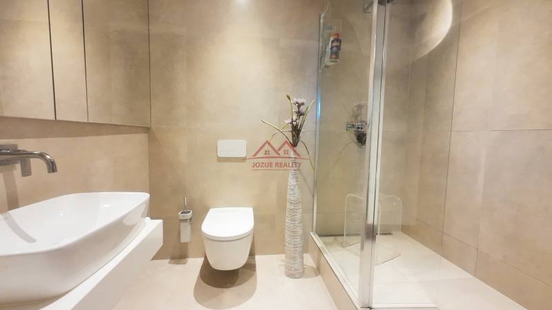 A bathroom in a 4-room apartment with white sanitary ware and a shower corner.