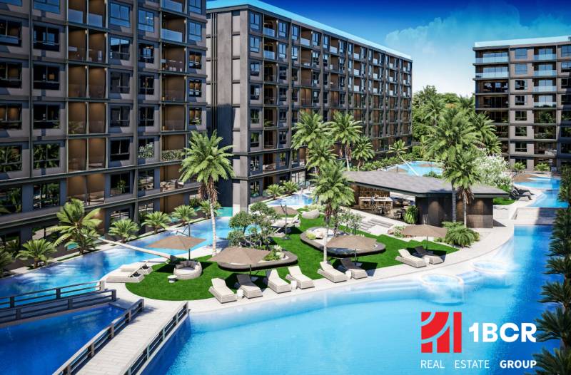 Apartment construction in Pattaya with a pool and palm trees offers a relaxing atmosphere.