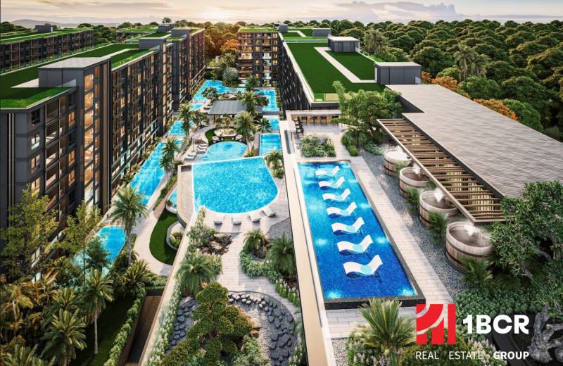Apartment construction in Pattaya with pools, green roofs, and abundant vegetation.