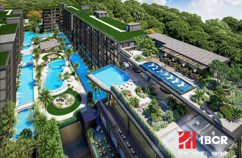 Apartment construction in Pattaya, featuring swimming pools and terraces with surrounding greenery.