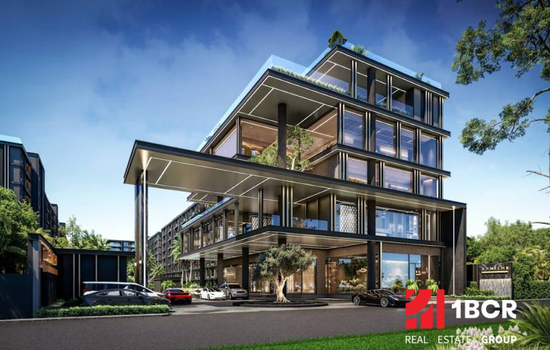 Construction of apartments in Pattaya with glass facades and greenery in the surroundings.