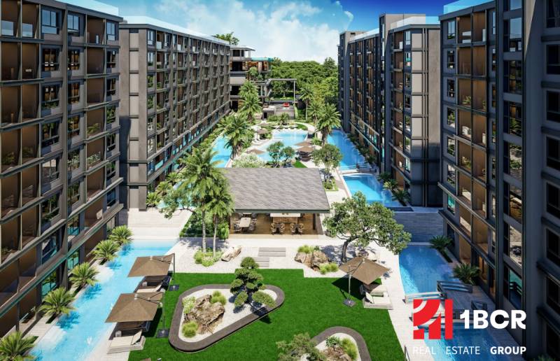 Apartment construction in Pattaya with a swimming pool, palm trees, and relaxation areas in the garden.