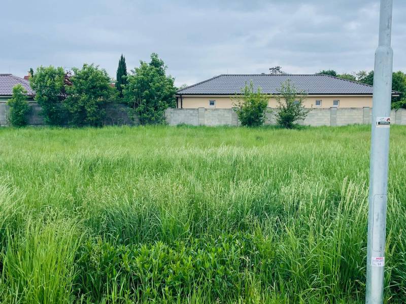 A plot for residential use on Podháj Street in Hviezdoslavov, surrounded by greenery and residential buildings.