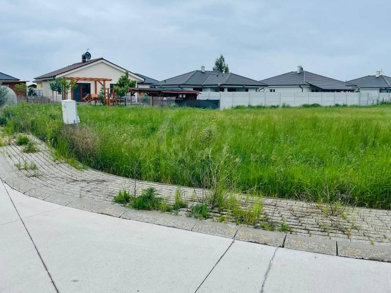 Plots - housing on Podháj Street in Hviezdoslavov, with grassy areas and family houses in the background.