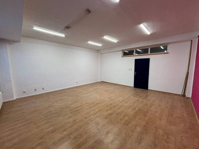 Spacious offices with wood-patterned flooring and white walls.