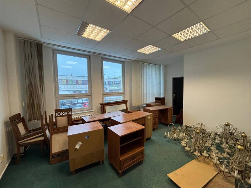 The interior of offices with furniture and chandeliers on a floor with wooden decor.