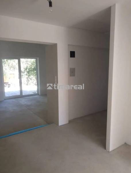 Interior of a family house with a concrete floor and sliding doors leading outside.