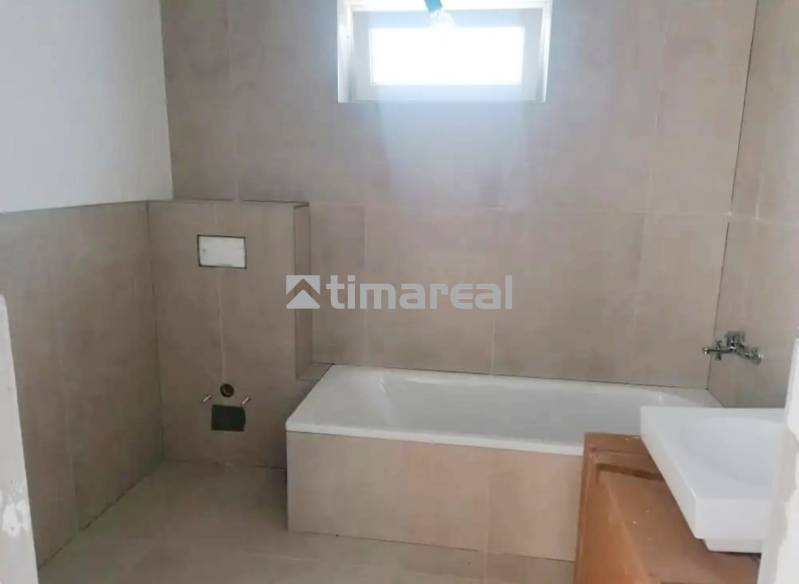 Bathroom in a family house with tiles and a bathtub.