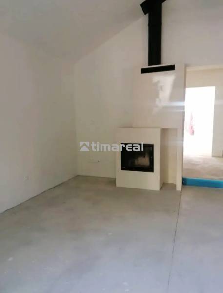 A room in a family house with a fireplace and a simple floor without decor.