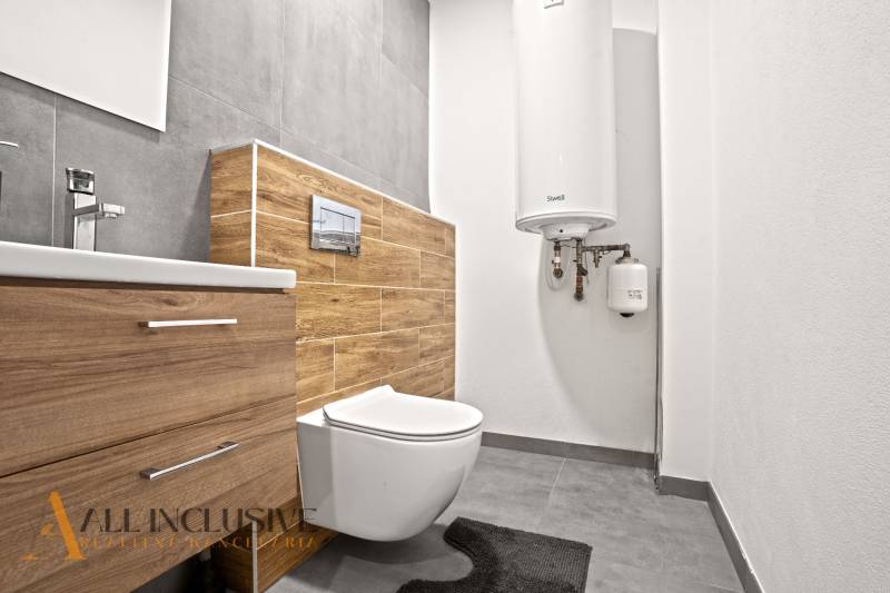 Bathroom in a 3-room apartment with a wooden decor floor and modern fixtures.