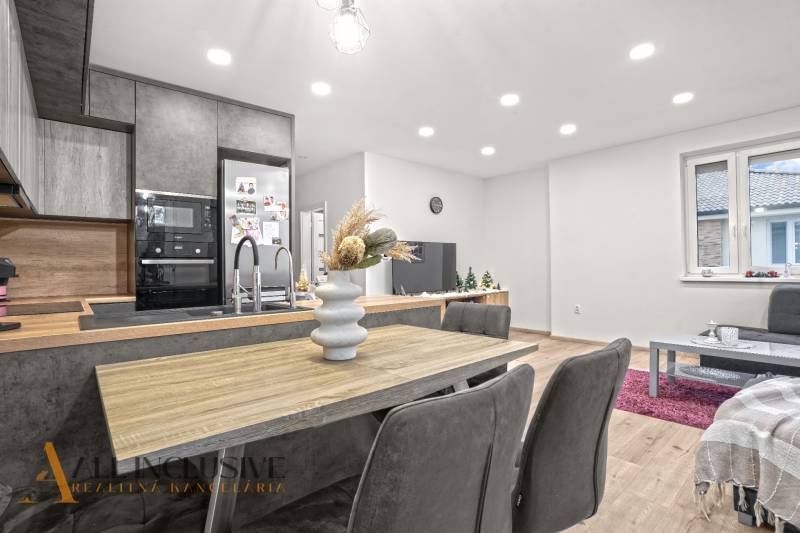A kitchen in a 3-room apartment with a wooden decor floor and a dining table.