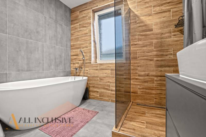 A bathroom in a 3-room apartment with a shower corner and a wooden decor floor.