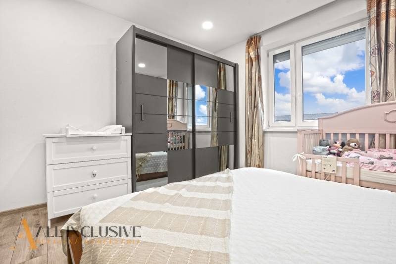 A children's room with a wooden decor floor, a wardrobe, and a crib in a 3-room apartment.