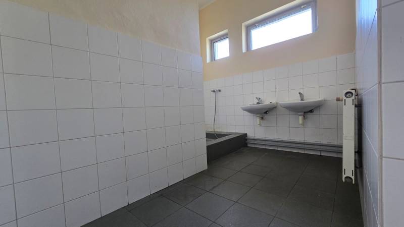 Bathroom in industrial warehouses and halls with sinks and tiles.