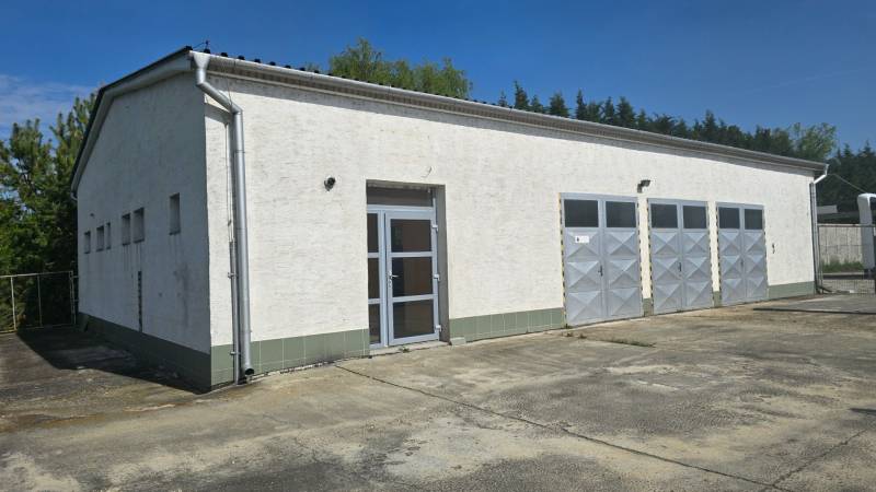 A white building with metal doors in the warehouse and hall zone of the city of Šaľa.