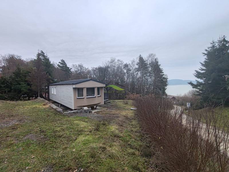 A cottage on Hlavná Street in Nová Kelča with a view of the water surface and forest.