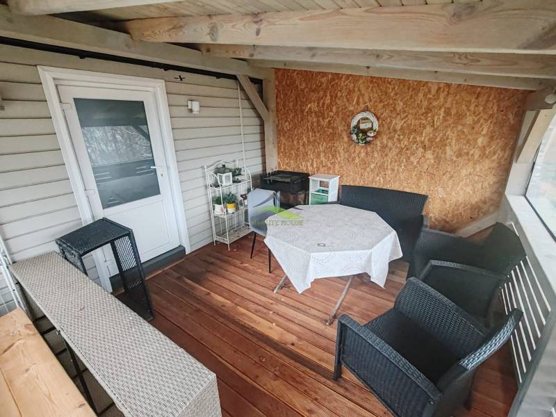 Cottage on Main Street in Nova Kelca, terrace with wood-patterned flooring.