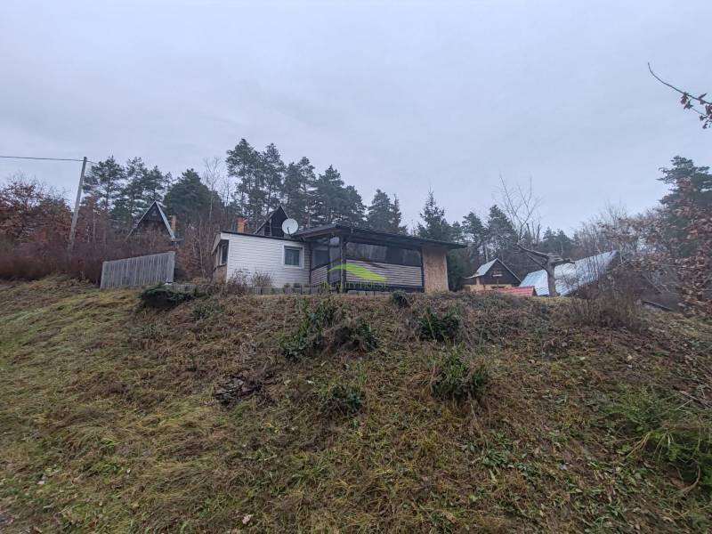 A cottage on a slope surrounded by nature on Main Street in Nova Kelc.