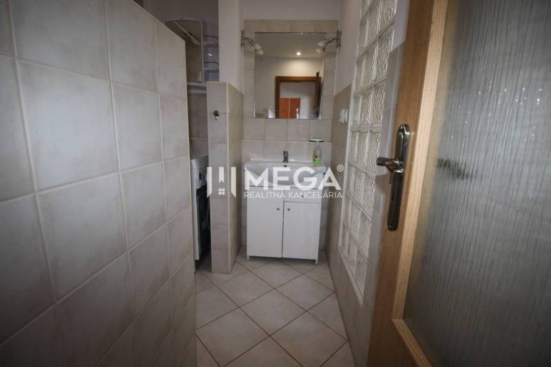 Bathroom in a 2-room apartment with a sink, mirror, and washing machine.