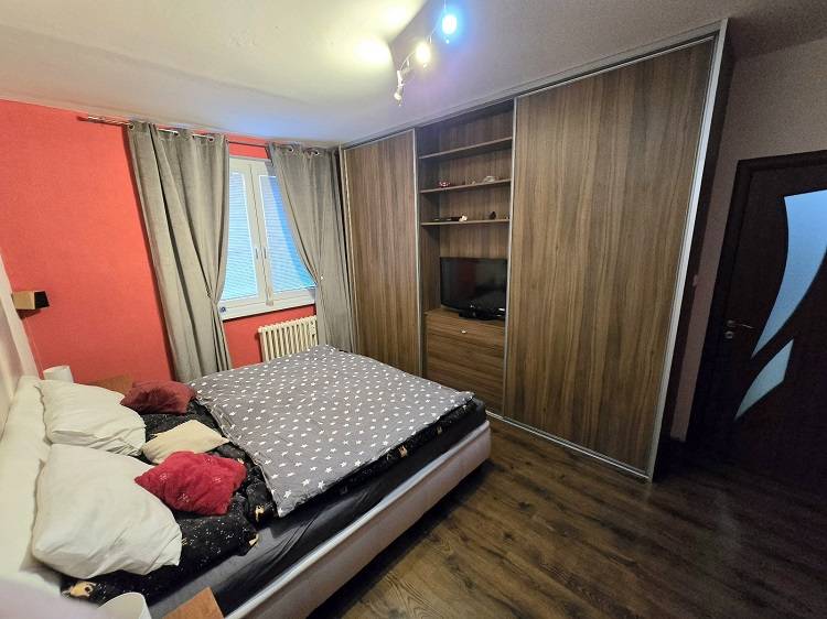 A bedroom in a 3-room apartment with a large wardrobe and a wooden decor floor.