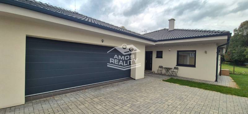 A family house in Studienka with two chairs and a table on a paved courtyard.