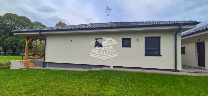 A family house in Studienka with a terrace, green lawn, and modern facade.