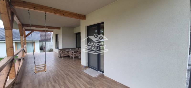 Terrace of a family house in Studienka with a swinging swing and furniture, flooring with a wooden decor.