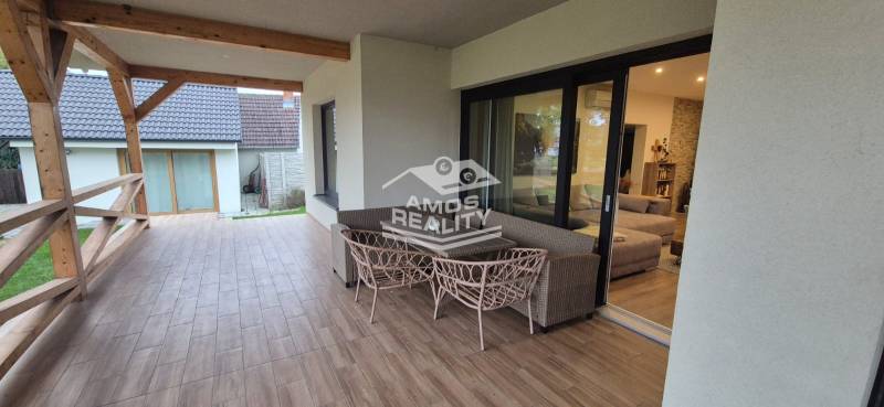 Terrace of a family house in Studienka with glass doors and a wooden decor floor.