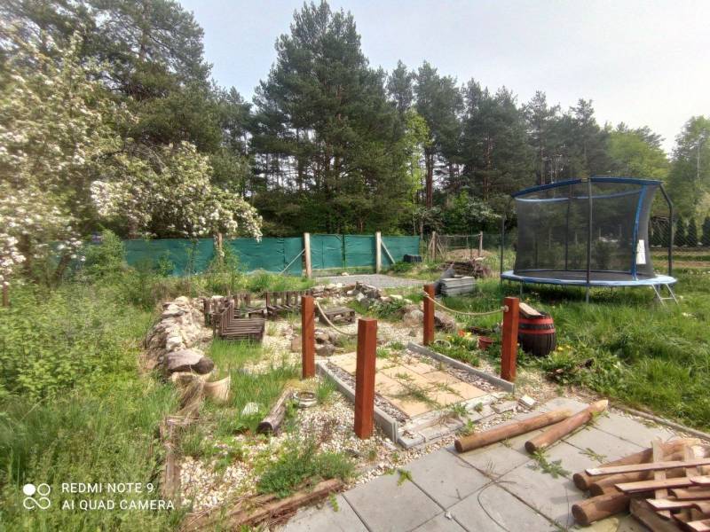 A garden by the cottage in Hliník nad Hronom with a trampoline and a wooden walkway.