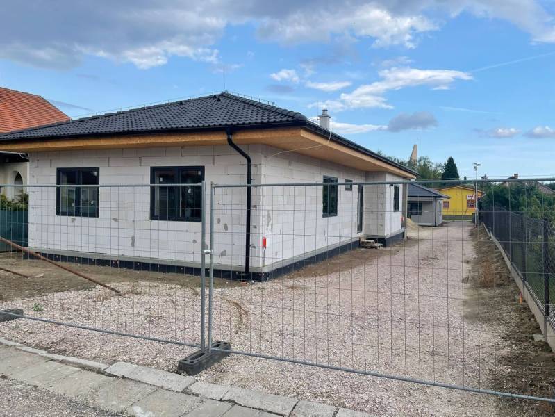 A family house with a sloped roof and white facade is being constructed in Radava.