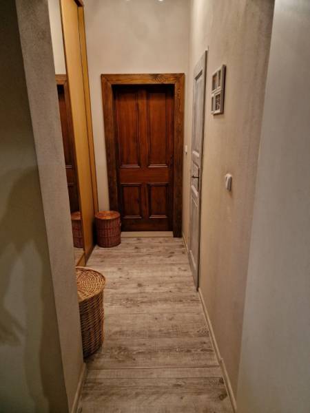 Hallway in a family house with doors and flooring featuring a wood design.