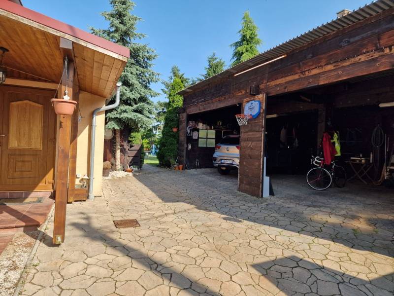 A family house in Dlhá nad Váhom with a shelter, garage, and landscaped yard.